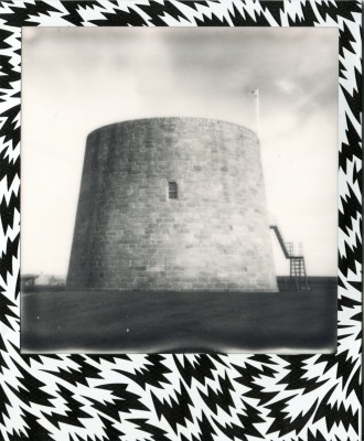 photograph of a tower/defensive structure.  This photograph has a border of geometric design