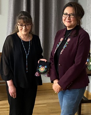 Cynthia presenting her beadwork piece to Janette for the Museum collection.