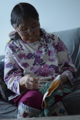 Photograph of a woman making a kamik